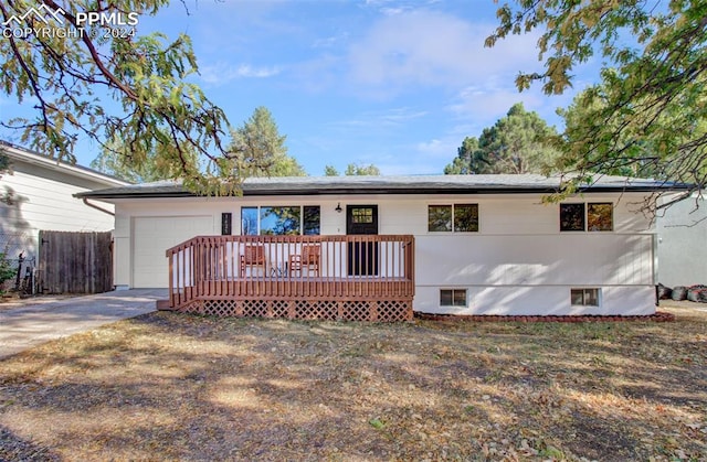 view of front facade featuring a wooden deck and a garage