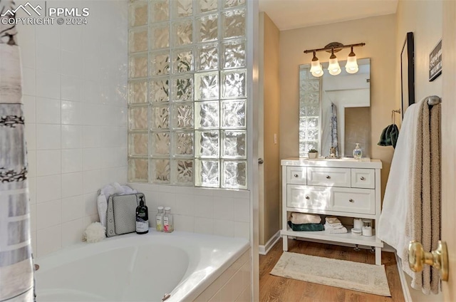 bathroom with vanity, hardwood / wood-style floors, and independent shower and bath