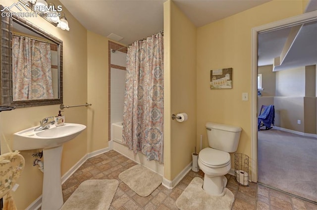 bathroom featuring toilet and shower / tub combo with curtain