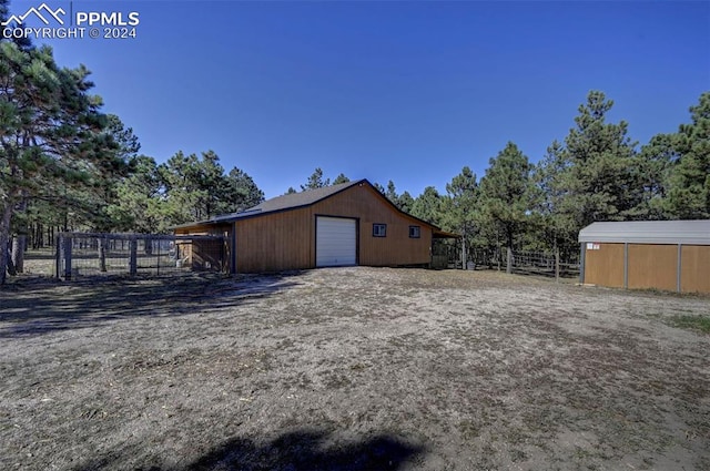 view of yard with a garage and an outbuilding