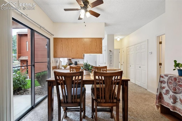 carpeted dining room with a textured ceiling and ceiling fan