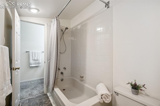 bathroom featuring toilet, shower / tub combo, and tile patterned flooring