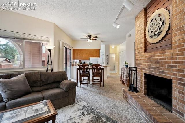 carpeted living room featuring a textured ceiling, ceiling fan, and a brick fireplace