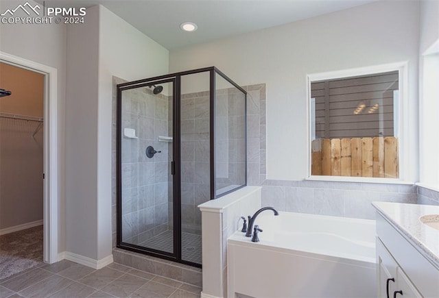 bathroom featuring vanity, shower with separate bathtub, and tile patterned floors