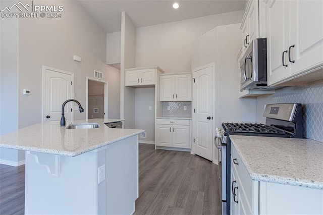 kitchen featuring appliances with stainless steel finishes, white cabinetry, sink, and an island with sink