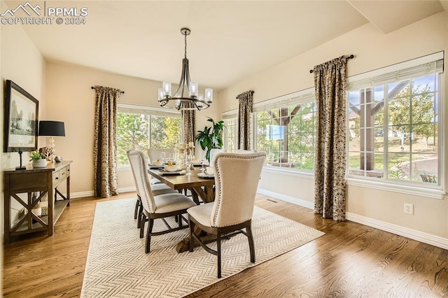 dining room with light hardwood / wood-style flooring, a notable chandelier, and plenty of natural light