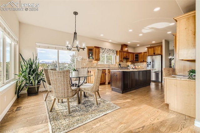 dining room with sink, a chandelier, light hardwood / wood-style floors, and plenty of natural light