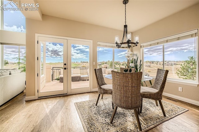 dining area featuring french doors, a notable chandelier, and light wood-type flooring