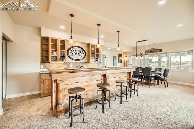 bar featuring hanging light fixtures, light colored carpet, and backsplash