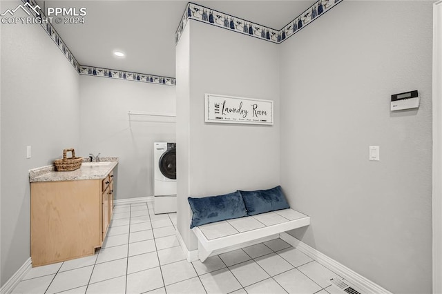 laundry area featuring sink, light tile patterned floors, and washer / clothes dryer