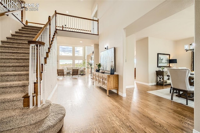 entrance foyer featuring a towering ceiling and hardwood / wood-style floors