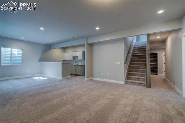 basement with sink and light colored carpet