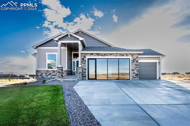 craftsman house featuring a front lawn and a garage