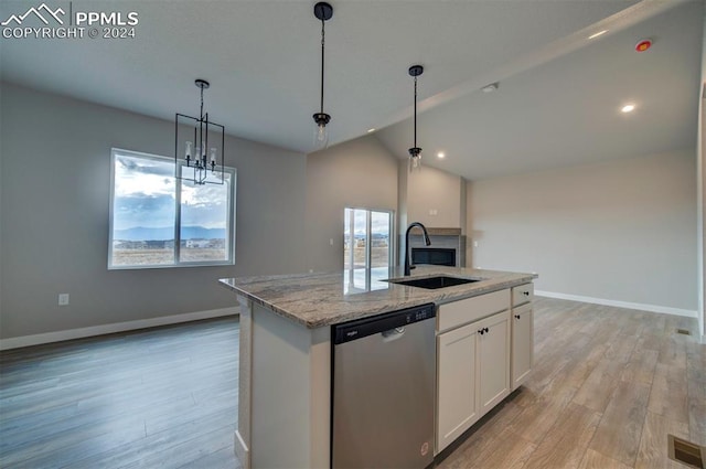 kitchen with white cabinetry, sink, stainless steel dishwasher, and an island with sink