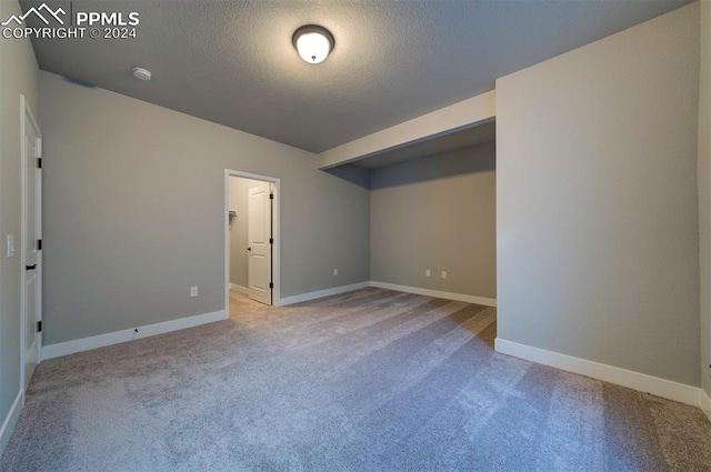 unfurnished bedroom with a closet, a textured ceiling, and light colored carpet