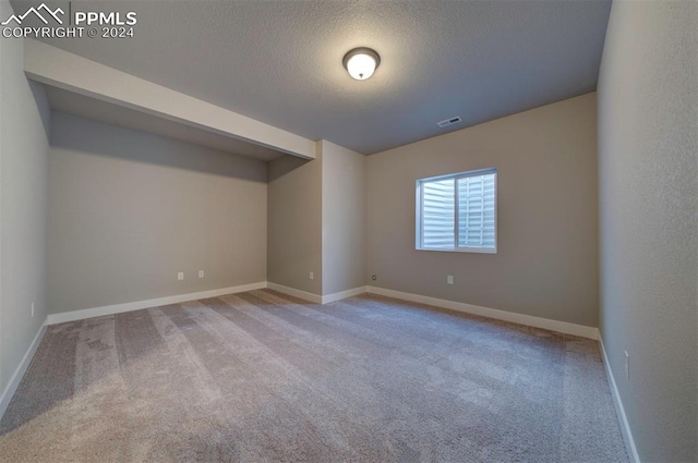 interior space featuring a textured ceiling and light colored carpet