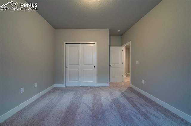 unfurnished bedroom with a closet and carpet