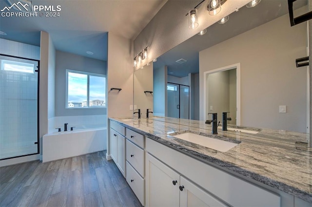 bathroom featuring vanity, wood-type flooring, and shower with separate bathtub