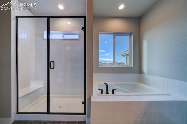 bathroom featuring shower with separate bathtub