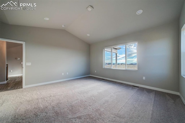 carpeted spare room featuring lofted ceiling