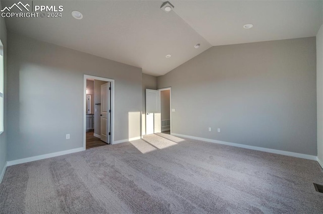 unfurnished bedroom with ensuite bathroom, lofted ceiling, and carpet floors