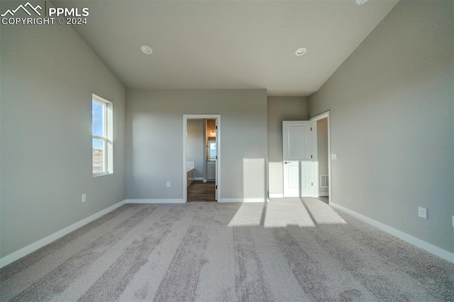 unfurnished bedroom featuring ensuite bath and light carpet