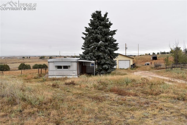 view of yard featuring a rural view and a garage