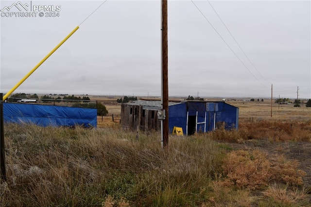 view of yard featuring an outdoor structure and a rural view