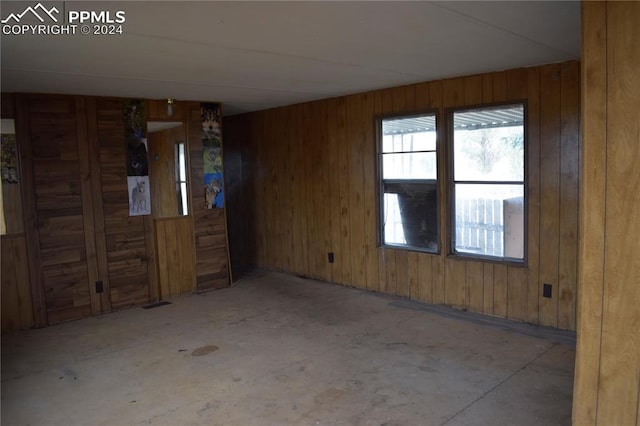 unfurnished room with wood walls