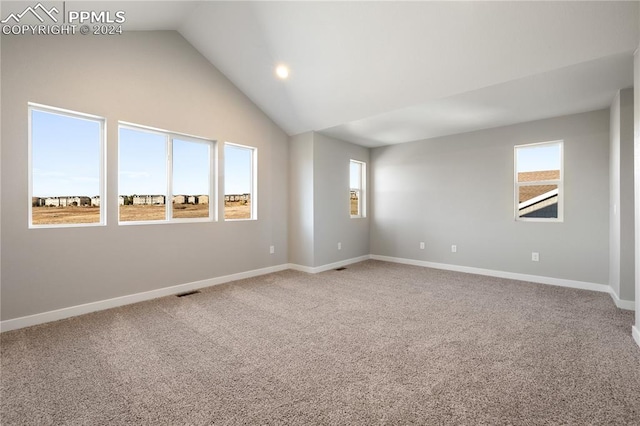 carpeted spare room featuring vaulted ceiling