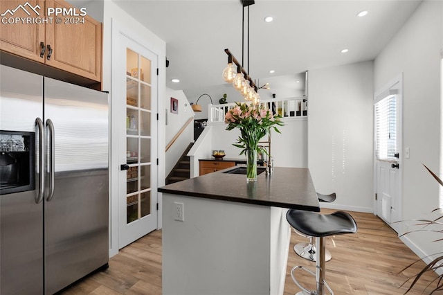 kitchen featuring sink, light hardwood / wood-style floors, stainless steel fridge with ice dispenser, and pendant lighting