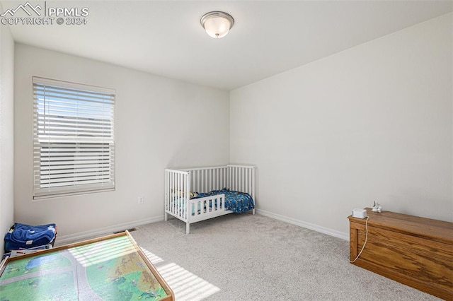 carpeted bedroom featuring a crib