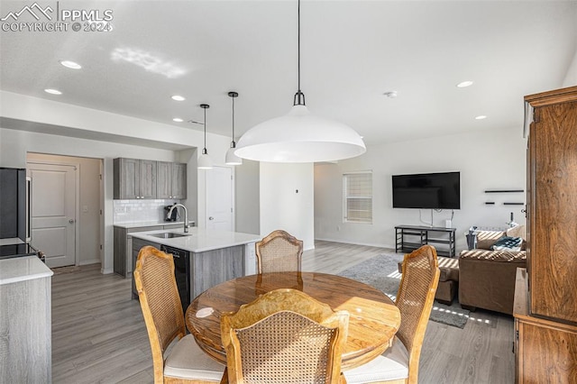 dining area with sink and light wood-type flooring