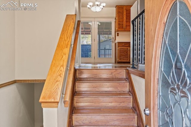 stairway featuring an inviting chandelier