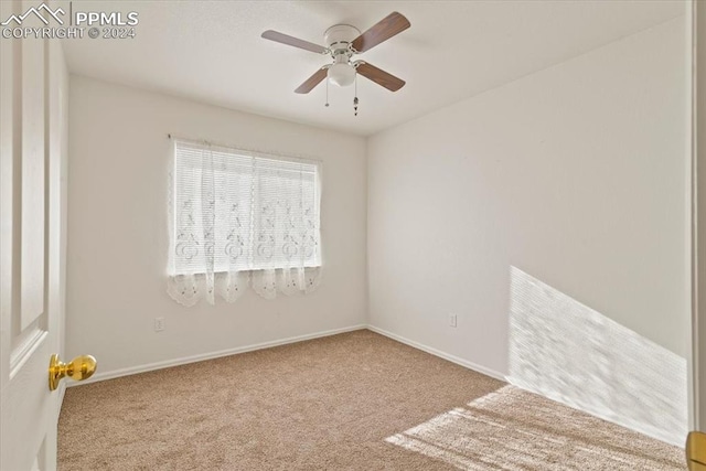 carpeted spare room with ceiling fan