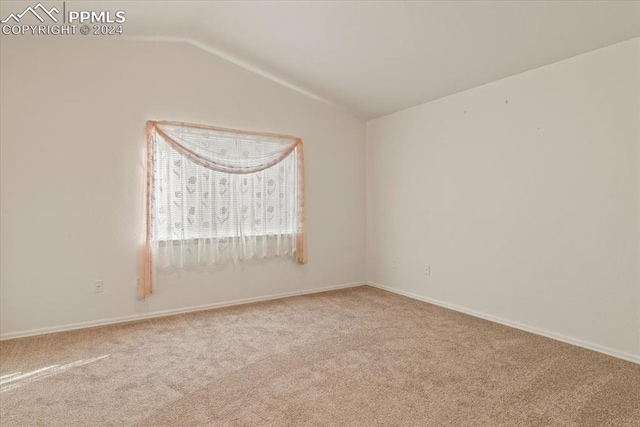 empty room featuring lofted ceiling and light colored carpet