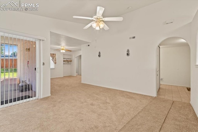 carpeted spare room with vaulted ceiling and ceiling fan