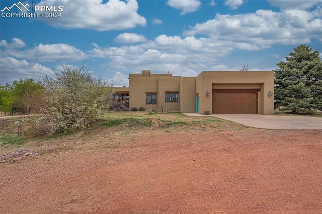 pueblo-style home with a garage