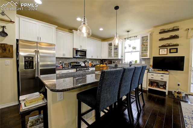 kitchen featuring tasteful backsplash, a center island, white cabinetry, stainless steel appliances, and dark wood-type flooring