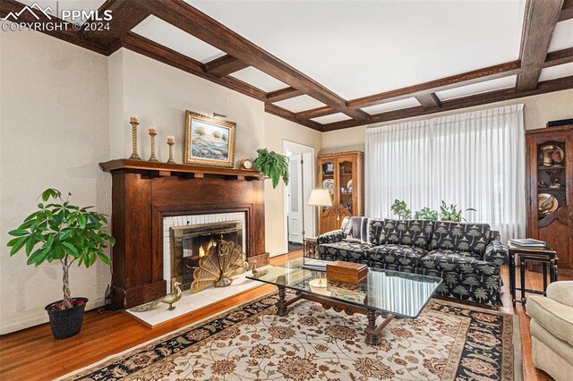 living room featuring wood-type flooring, coffered ceiling, and beam ceiling