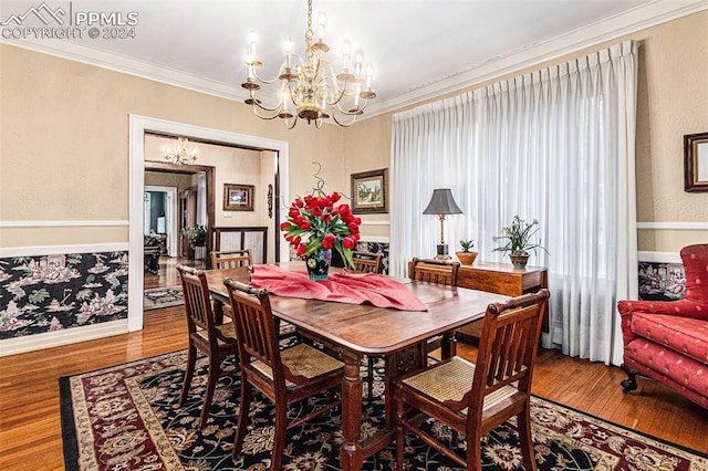 dining space with crown molding, hardwood / wood-style floors, and a chandelier