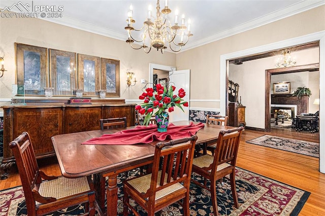 dining room with wood-type flooring, crown molding, and a chandelier