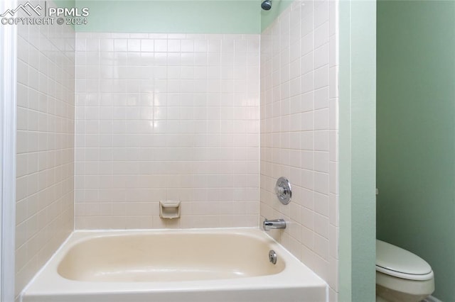 bathroom with toilet and tiled shower / bath combo