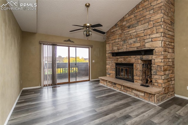 unfurnished living room with lofted ceiling, ceiling fan, dark hardwood / wood-style flooring, a textured ceiling, and a fireplace