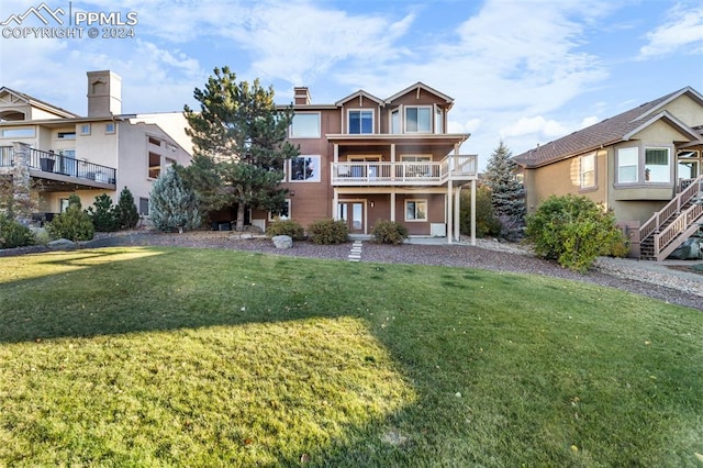 view of front of property featuring a front yard and a balcony