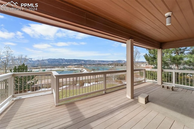 wooden terrace with a water and mountain view