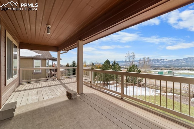 wooden deck with a water and mountain view