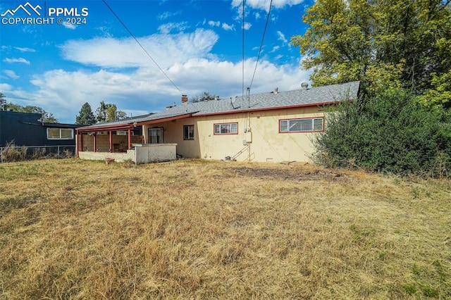 back of house featuring a lawn