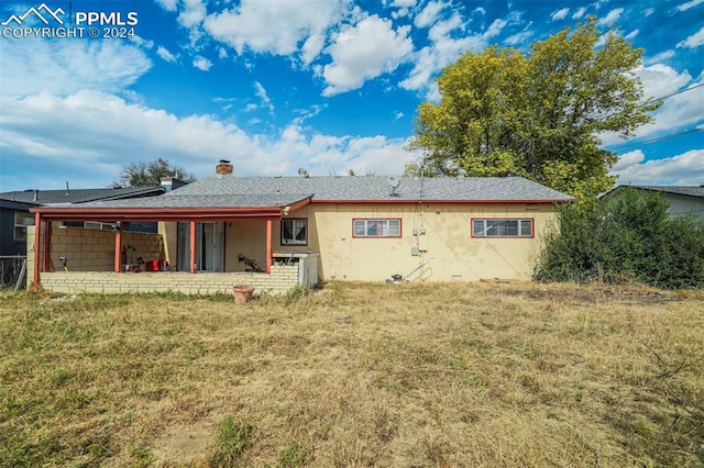 back of property with a patio area and a lawn