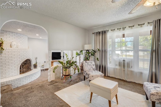 carpeted living room featuring a textured ceiling and a brick fireplace